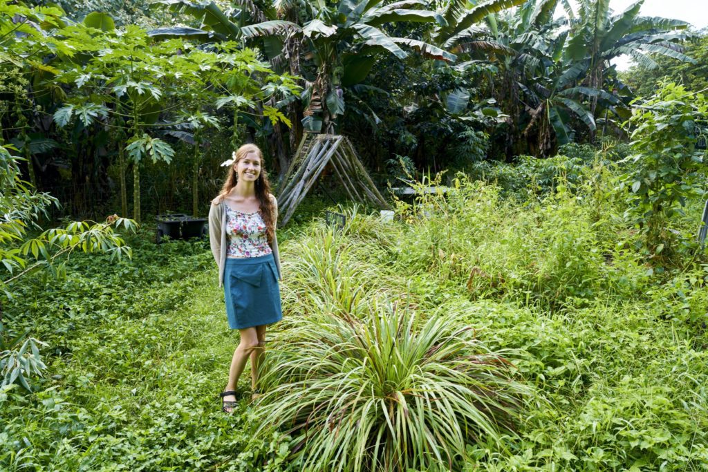 A Kalani volunteer giving tour of the fenced gardens and raised beds