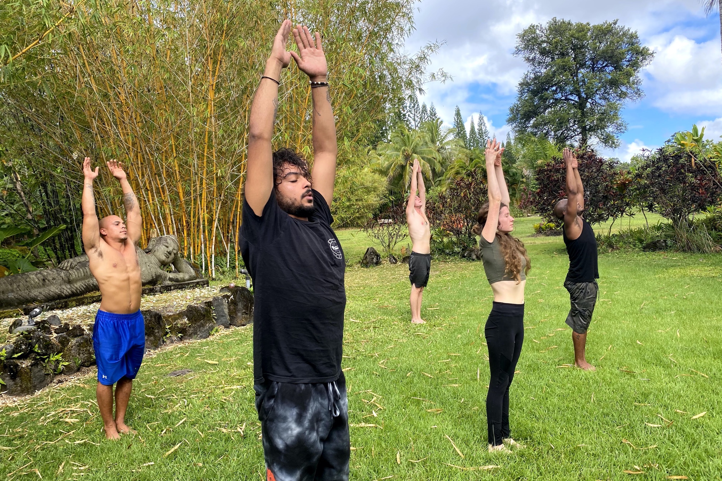 Guests doing yoga in the lawns by the buddha statue