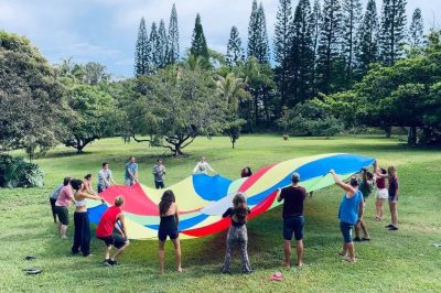 Kalani work-trade crew participating in parachute team building activity_resize